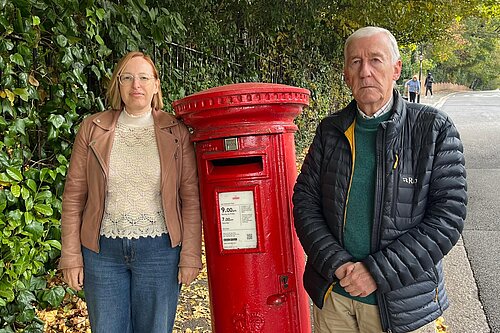 Claire Bonham and Nigel Dingley by a postbox on Highfield Hill